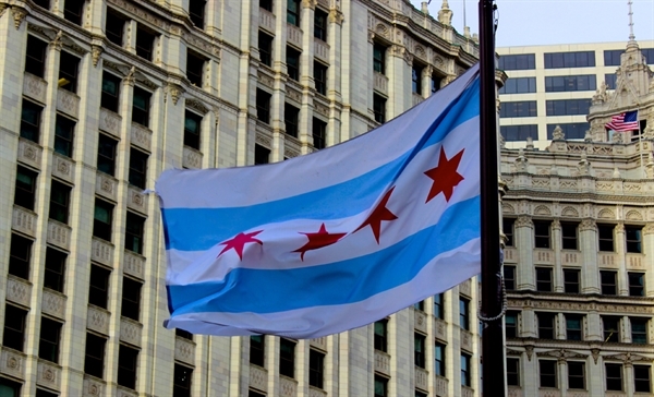 Chicago city flag flying in front of buildings in Chicago's Loop